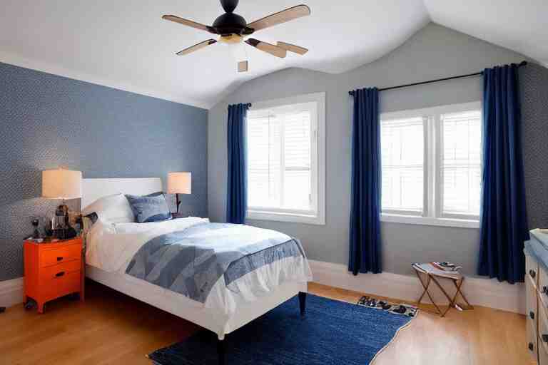 a 10 by 11 foot old bed room with blue grey criss cross patterned walls, white ceiling, navy blue carpet, a small bed, desk, two wooden wardrobes, an old TV, and a ceiling fan gives off a dim orange light at night time